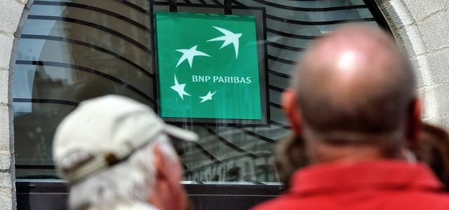 People walk in front of the entrance of a French bank BNP Paribas on June 24, 2014 in Lille, northern France. AFP PHOTO / PHILIPPE HUGUEN